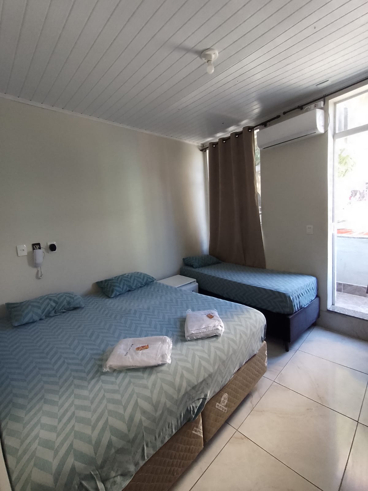Quarto do Hotel Anacleto com cama de casal e cama de solteiro